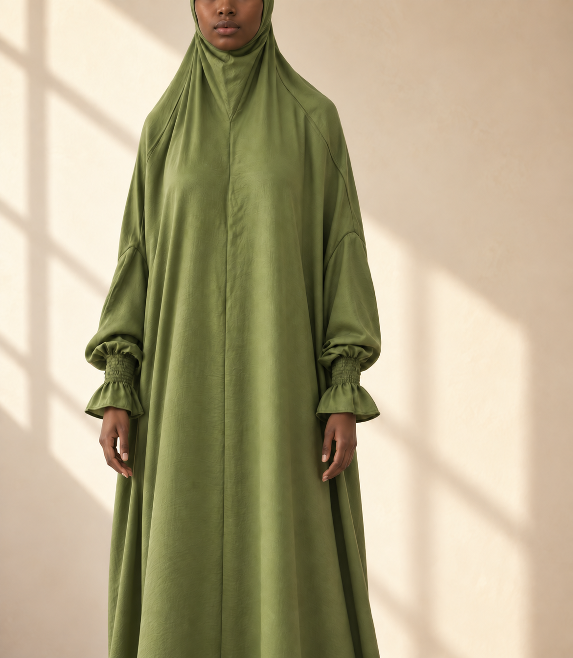 Model wearing a one-piece jilbab with integrated head covering