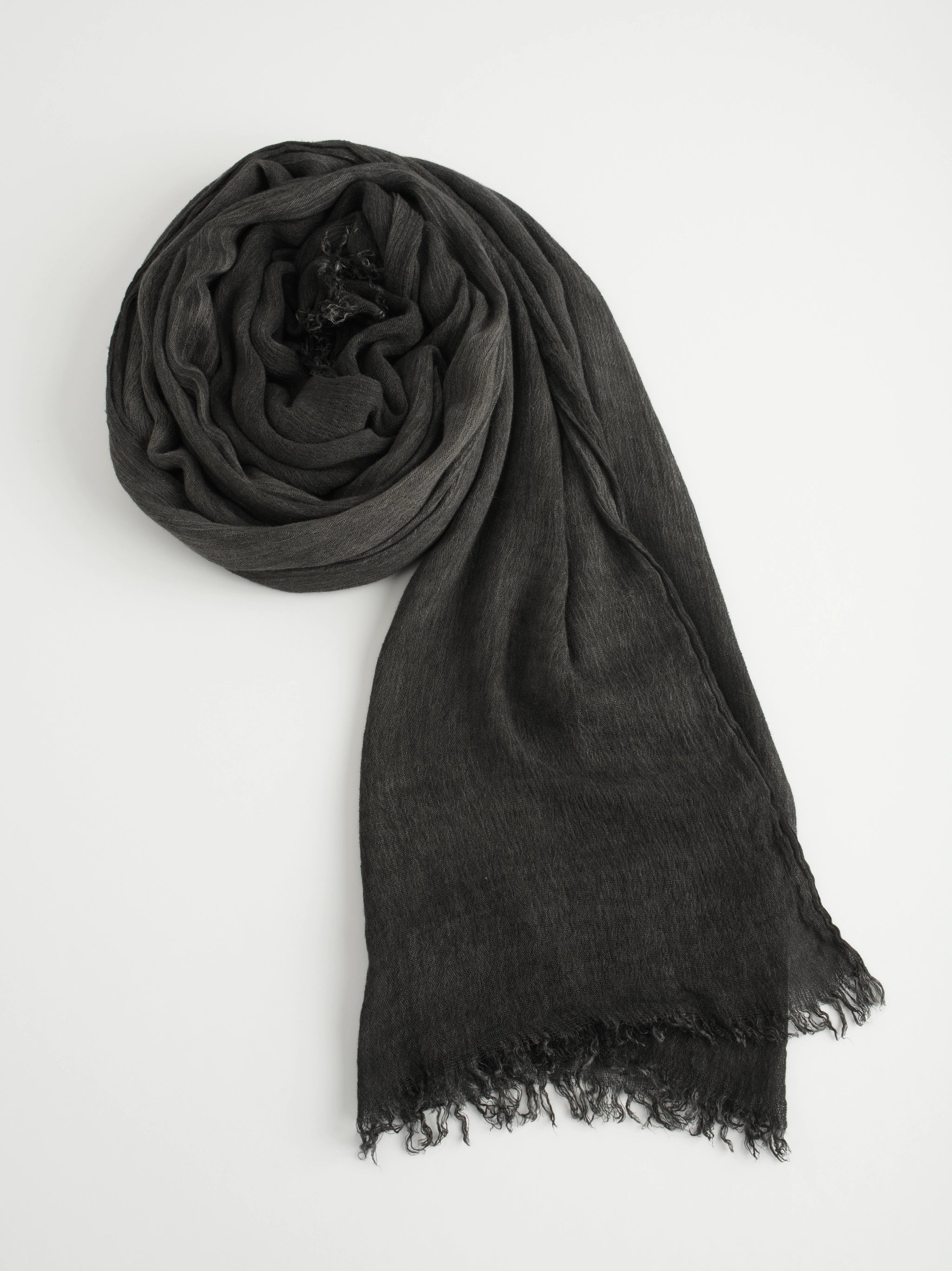 Black crinkle scarf with frayed edges on a white background