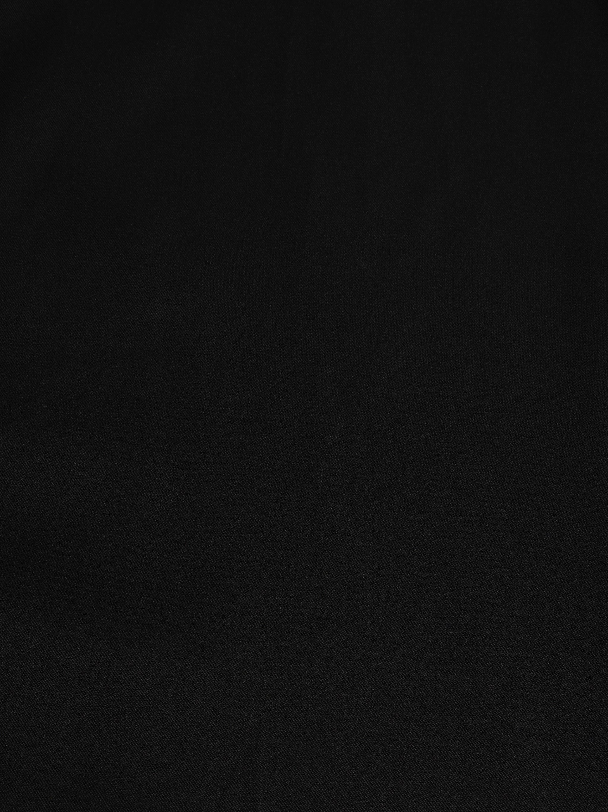 Close-up of Black palazzo pants showing the texture of the soft crepe fabric for the modest, wide-leg cut.